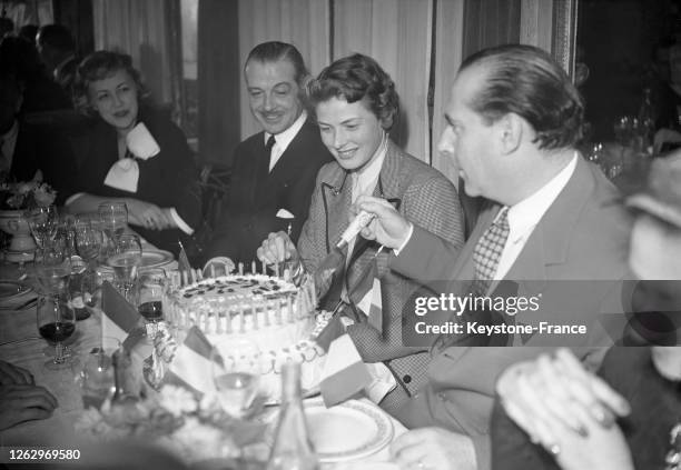 Le réalisateur italien Roberto Rossellini célébrant son anniversaire dans un restaurant avec son épouse, l'actrice Ingrid Bergman, à Paris, le 8 mai...