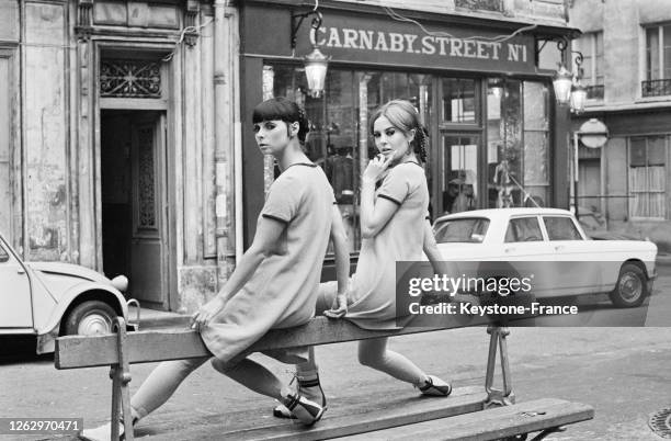 Devant un magasin 'Carnaby Street', deux femmes présentent la mode britannique, à Paris, France le 22 novembre 1966.