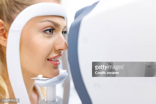 giovane donna che controlla gli occhi dell'oftalmologo - occhio umano foto e immagini stock