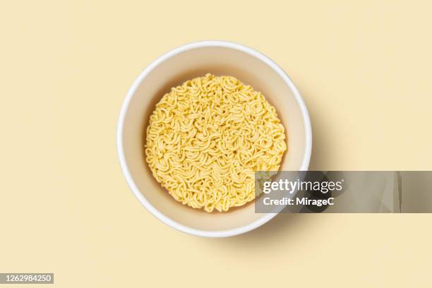 dry uncooked instant noodles in a paper bowl - instant noodles stock pictures, royalty-free photos & images