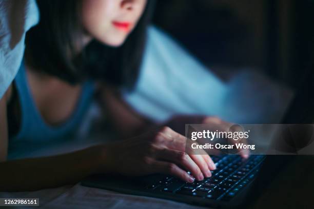 close-up shot of young woman working late with laptop in the dark - arabic keyboard fotografías e imágenes de stock
