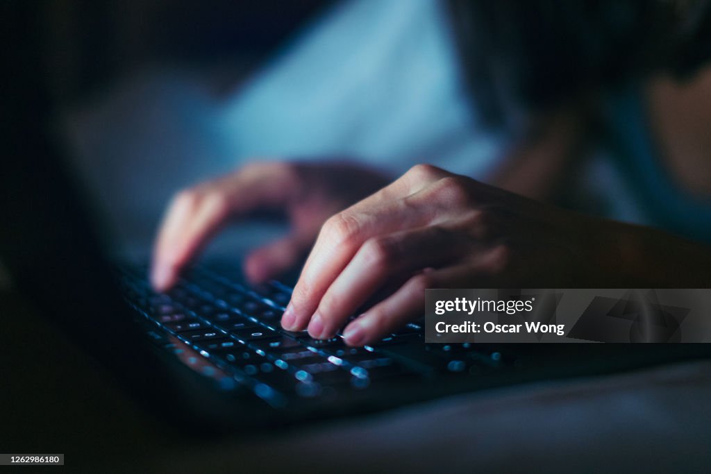 Close-up Shot Of Young Woman Working Late With Laptop In The Dark