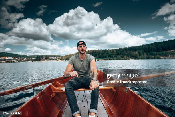 ung man rodd på en sjö i tyskland - rowboat bildbanksfoton och bilder