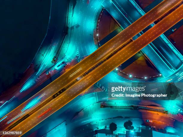 aerial top view, expressway road roundabout intersection or circle at night for transportation that facilitates the travel of car users on the road transportation or futuristic concept. ( reflective color tone ) - 情報スーパーハイウェイ ストックフォトと画像