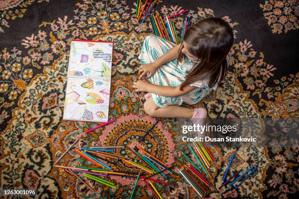 mädchen mit malbuch auf dem teppich - persian rug stock-fotos und bilder