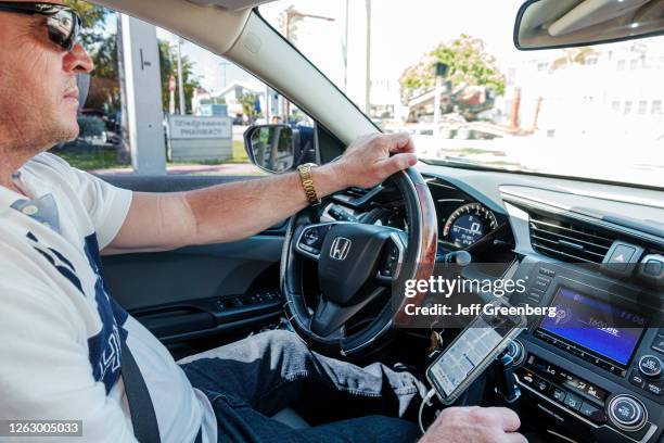 Florida, Miami Beach, Uber, ridesharing service, driver with dashboard mounted smartphone.