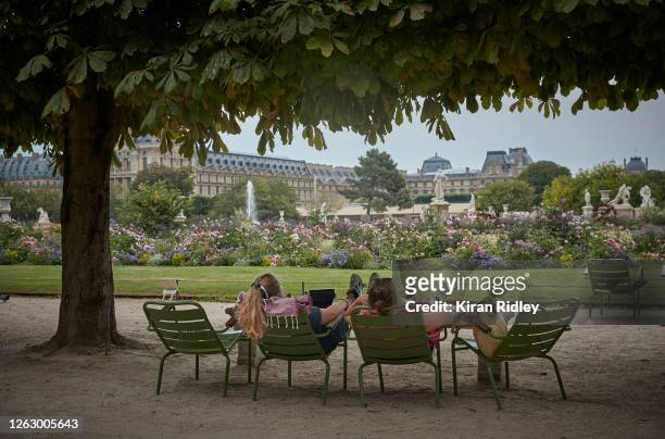Parisians relax in the shade of the Tuileries Garden next to the Louvre Museum, as Paris records it highest temperature on record on July 31, 2020 in...