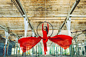 Young woman doing aerial hoop dance in abandoned building
