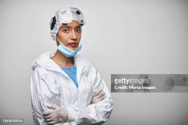 portrait of young female doctor in protective workwear - doctors arms crossed stock pictures, royalty-free photos & images