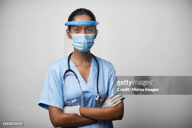 portrait of young female doctor/nurse in protective workwear - face mask protective workwear stockfoto's en -beelden