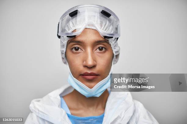 portrait of indian female nurse in protective workwear - face mask coronavirus photos et images de collection