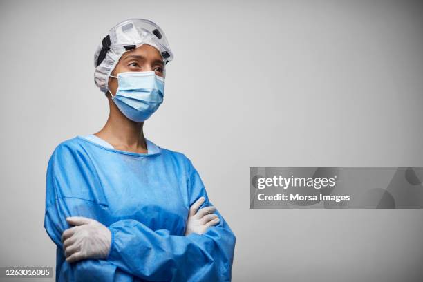 portrait of female doctor/nurse in protective workwear - portrait white background looking away stock pictures, royalty-free photos & images