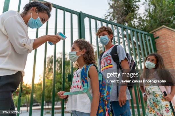 teacher checks temperature of students at school - epidemic school stock pictures, royalty-free photos & images