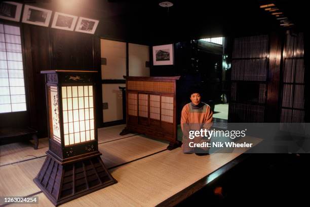 Hotel owner kneels to greet arriving guests at traditional Japanese style ryokan in Nara