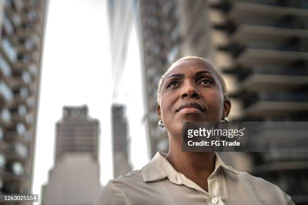 businesswoman loking away outdoors - confidence stock pictures, royalty-free photos & images