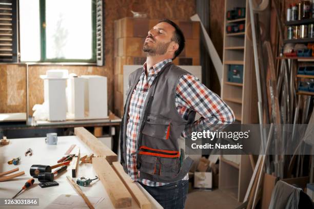 falegname con mal di schiena - mal di schiena foto e immagini stock
