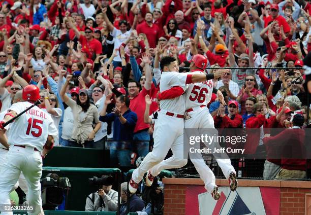 Adron Chambers of the St. Louis Cardinals celebrates with Yadier Molina after scoring on a wild pitch by Carlos Marmol of the Chicago Cubs in the...