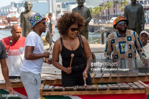 Cape Town, South Africa, Street musician in revealing black top plays xylophone on the waterfront area of central Cape Town.