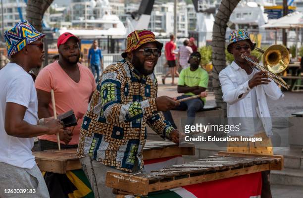Cape Town, South Africa, Street musician in colorful clothing plays xylophone on the waterfront area of central Cape Town.
