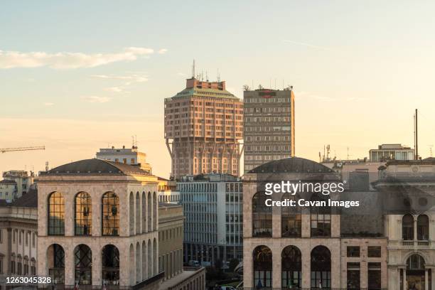 buildings at cathedral square duomo with torre velasca - milan stock pictures, royalty-free photos & images