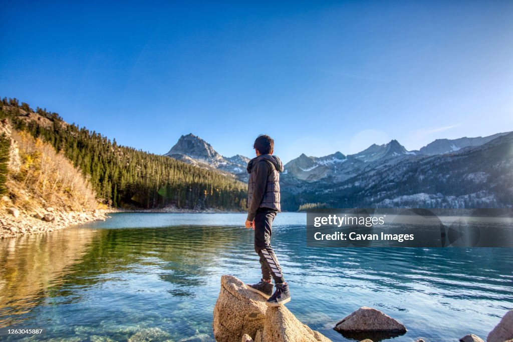 Boy looking over a lake in the Sierras, California.