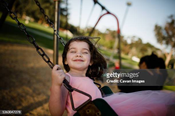 young girl on swing, closing eyes and smiling - animal body part stock pictures, royalty-free photos & images