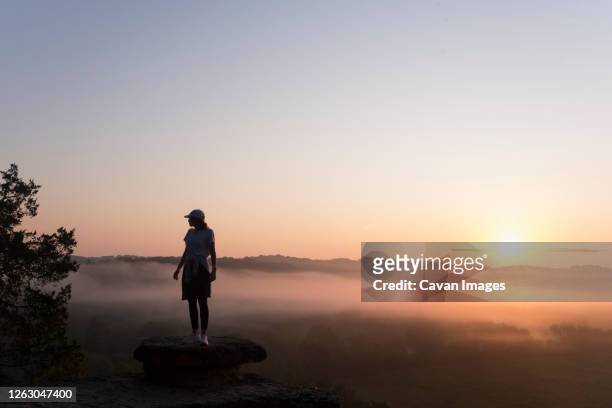 silhouette of girl hiking on mountain top at sunrise - nashville sunrise stock pictures, royalty-free photos & images