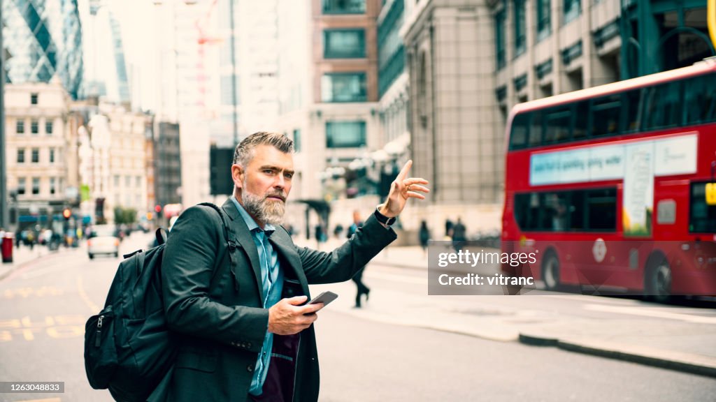 Businessman calling a taxi in London