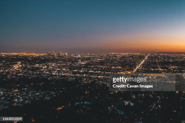 aerial wide view over glowing los angeles, california city lights scape - downtown los angeles aerial stock pictures, royalty-free photos & images