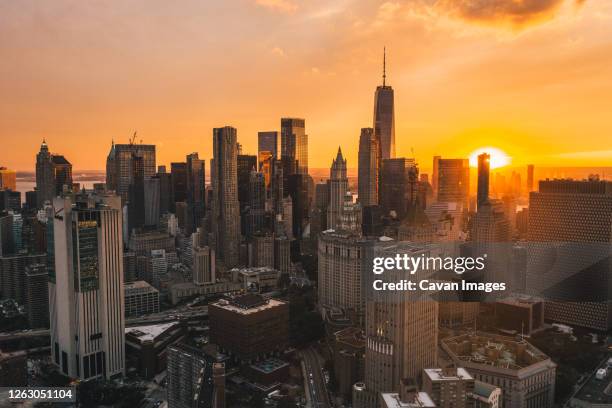 uptown manhattan in golden hour sunset light with skyline of skyscrapers drone shot - rooftop new york photos et images de collection