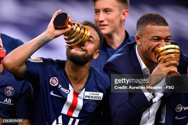 Neymar Jr and Kylian Mbappe of Paris Saint-Germain raise the Trophy after winning the French League Cup final match against Olympique Lyonnais after...