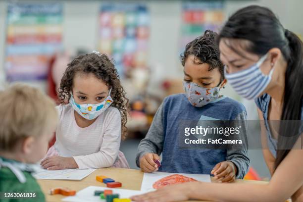 group of children colouring while wearing masks - protective face mask stock pictures, royalty-free photos & images