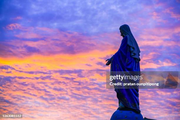 silhouette of mother mary statue against beautiful twilight sky - miracle stock pictures, royalty-free photos & images