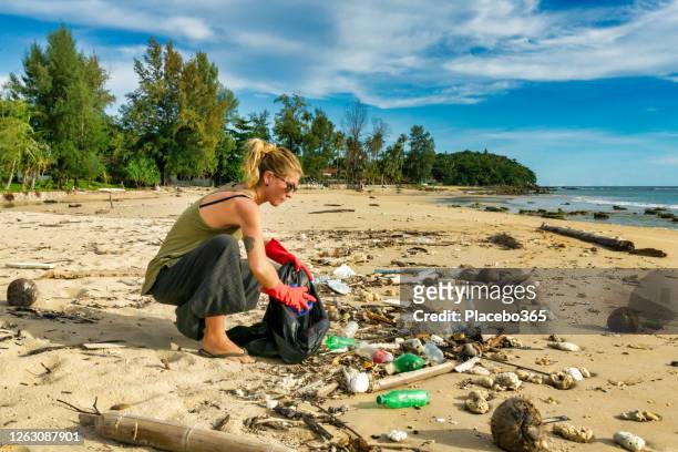 environmental cleanup one woman koh lanta beach thailand - plastic pollution beach stock pictures, royalty-free photos & images
