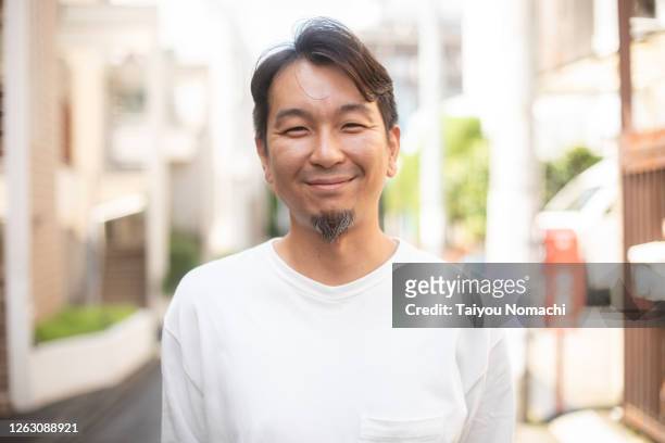 portrait of a smiling japanese man on the street - japanischer abstammung stock-fotos und bilder