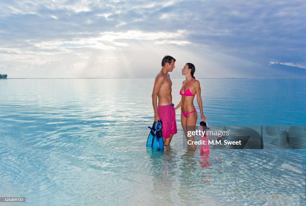 Romantic couple holding snorkel gear