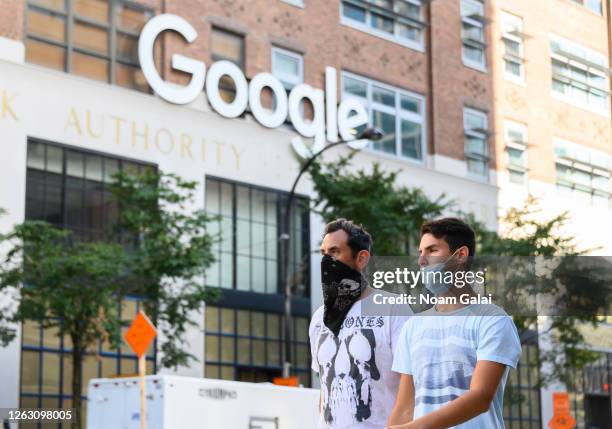 People wear protective face masks outside the Google offices in Chelsea as the city continues Phase 4 of re-opening following restrictions imposed to...