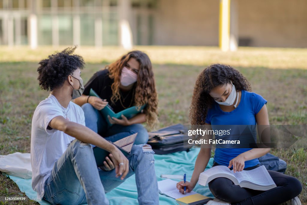 Multi-ethnic group of students wearing masks on campus