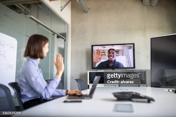 businesswoman having a video call with a colleague - remote location stock pictures, royalty-free photos & images