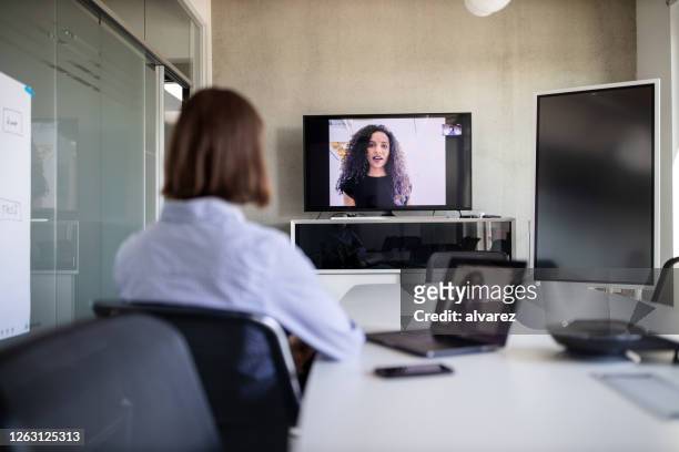 businesswoman planning with a coworker on video call - remote location stock pictures, royalty-free photos & images