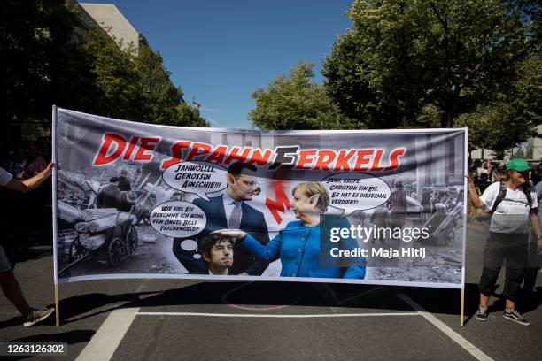 Protesters against coronavirus restrictions demonstrate with poster that shows the chancellor Angela Merkel, minister of health Jens Spahn and German...