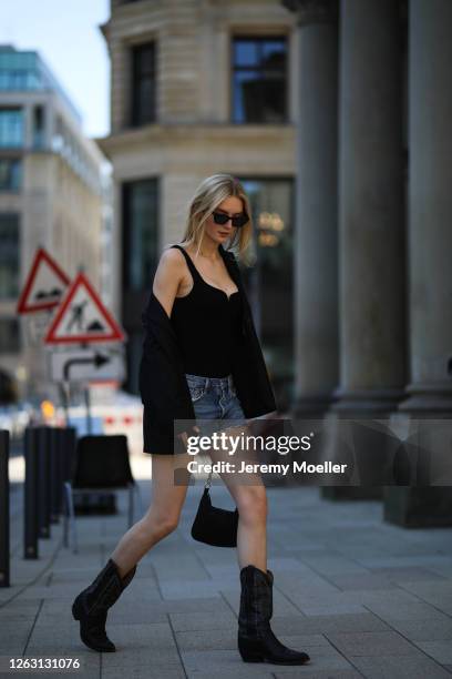 Eva Staudinger wearing &other stories body and blazer, Agolde jeans shorts, vintage cowboy boots on July 31, 2020 in Hamburg, Germany.