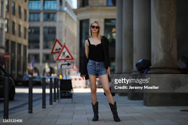 Eva Staudinger wearing &other stories body and blazer, Agolde jeans shorts, vintage cowboy boots on July 31, 2020 in Hamburg, Germany.
