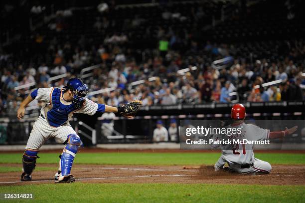 Wilson Valdez of the Philadelphia Phillies scores a run in the second inning against catcher Josh Thole of the New York Mets during a game at Citi...