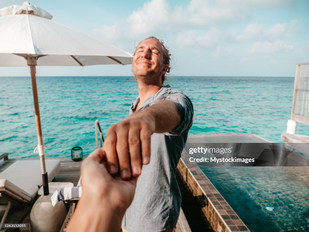 Couple holding hands in the Maldives