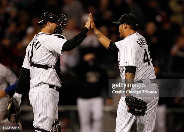 Chicago White Sox catcher A.J. Pierzynski, left, celebrates with relief pitcher Sergio Santos at the end of a 6-3 win over the Kansas City Royals at...