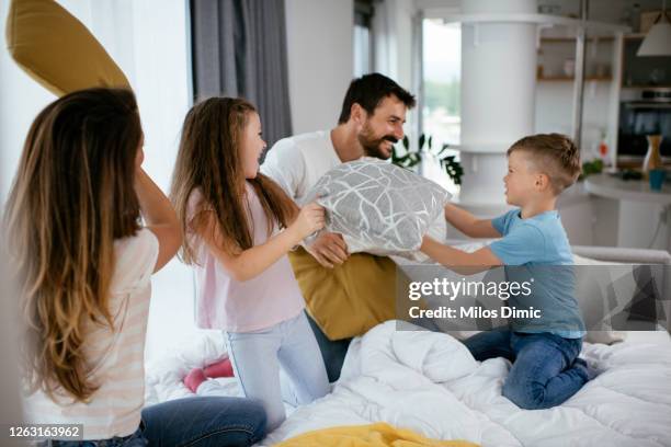 beautiful family having a pillow fight stock photo - father and child and pillow fight stock pictures, royalty-free photos & images