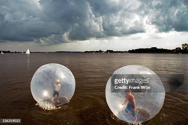 children in balls on water - transparent plastic stock pictures, royalty-free photos & images