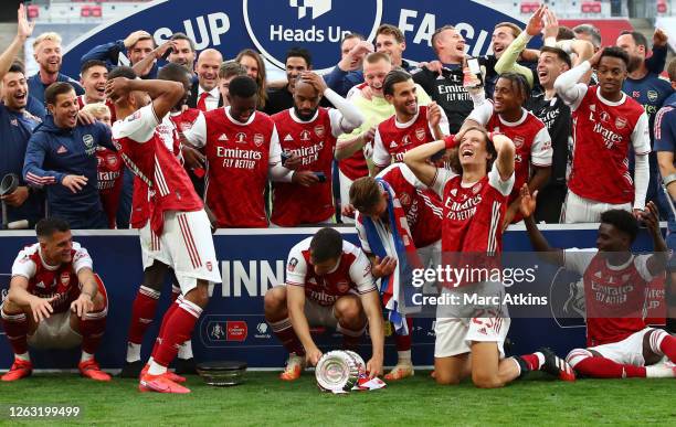 Arsenal players react as Arsenal captain Pierre-Emerick Aubameyang of Arsenal drops the FA Cup Trophy following the FA Cup Final match between...