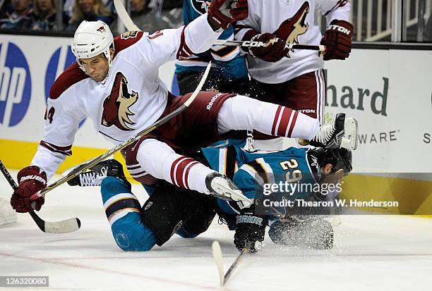 Taylor Pyatt of the Phoenix Coyotes is knocked off his skates by Ryane Clowe of the San Jose Sharks in the third period during an NHL pre-season...